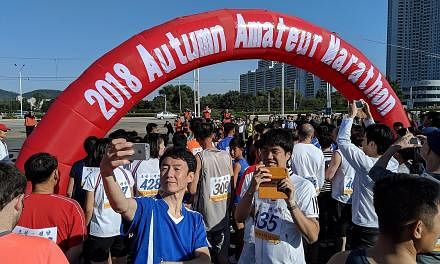 Runners taking selfies at the flag-off point of the Pyongyang Autumn Amateur Marathon on Sept 23. The run is geared at amateur runners amid burgeoning interest in long-distance running, said the organisers.
