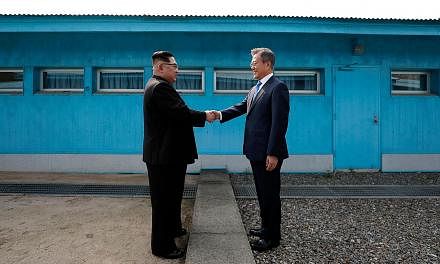 North Korea's leader Kim Jong Un (left) with South Korea's President Moon Jae-in at the Military Demarcation Line that divides their countries at Panmunjom on April 27. Mr Kim accepted Mr Moon's invitation to visit Seoul during their meeting in Pyong