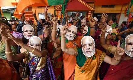 Supporters of the Bharatiya Janata Party (BJP), some wearing masks of Indian Prime Minister Narendra Modi, celebrating the decisive mandate won by their party on Thursday at the BJP office in Guwahati.