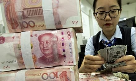 A bank employee counts US dollars next to a stack of Chinese yuan in eastern China's Jiangsu province. Yesterday's developments mean currency issues are now being dragged into the debate on trade and even monetary policy. PHOTO: ASSOCIATED PRESS