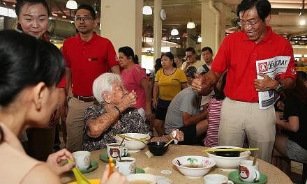 Singapore Democratic Party's Dr Chee Soon Juan and an elderly resident giving each other the thumbs up during his walkabout in Yuhua with party members on Aug 4. SDP plans to launch its manifesto soon and hold a pre-election rally next month.