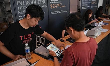 A subscriber collecting his Samsung Tab A 10.1-inch Wi-Fi tablet pre-loaded with the ST app at Plaza Singapura yesterday. Adjustments to the queue system have shortened the waiting time for subscribers collecting their tablets to about 10 to 15 minut