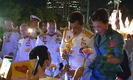 King Vajiralongkorn receiving flowers from a supporter. He greeted his adoring supporters after paying respects at a monument dedicated to his late grand-uncle, King Vajiravudh. Royalists waving flags and holding pictures of King Vajiralongkorn at Lu