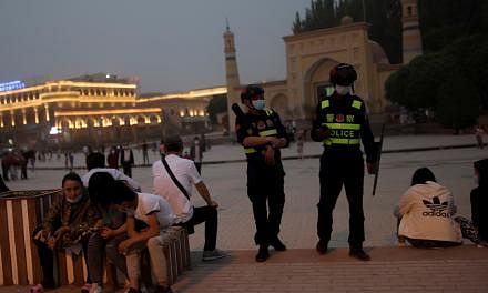 <p>FILE PHOTO: Police officers patrol the square in front of Id Kah Mosque in Kashgar, Xinjiang Uyghur Autonomous Region, China, May 3, 2021. Picture taken May 3, 2021.  REUTERS/Thomas Peter/File Photo</p>