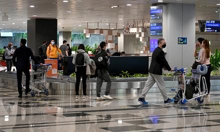 <p>Passengers wearing face masks collecting luggages at Changi Airport Terminal 3 on November 5, 2021. The expanded Vaccinated Travel Lane (VTL) scheme in Singapore has given the meetings, incentives, conventions and exhibitions (Mice) sector a boost, wi
