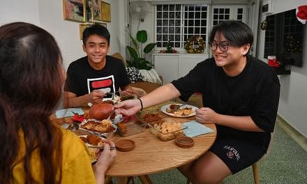 Jesper Ng (left) and Jessel Ng have a meal with their mother at their newly renovated flat on Dec 21, 2021.
