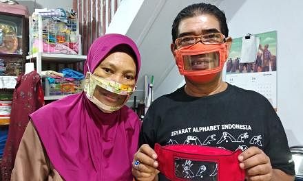 <p>Imam Saroso (R) and his wife Faizah Badaruddin (L), who are hearing and speech-impaired, pose with homemade face masks which enables people with disabilities like them to read lips when communicating, in Makassar, South Sulawesi, on April 28, 2020 amid