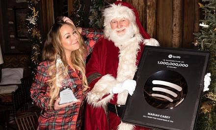 Mariah Carey shared a series of festive photos, one of which was her posing with Santa and a plaque from Spotify.