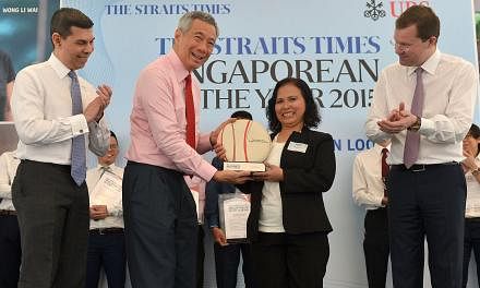 PM Lee presenting Madam Noriza with the Singaporean of the Year trophy at the UBS Business University yesterday. With them are Straits Times Editor Warren Fernandez (left) and Mr Juerg Zeltner, president of UBS Wealth Management. Madam Noriza hopes h
