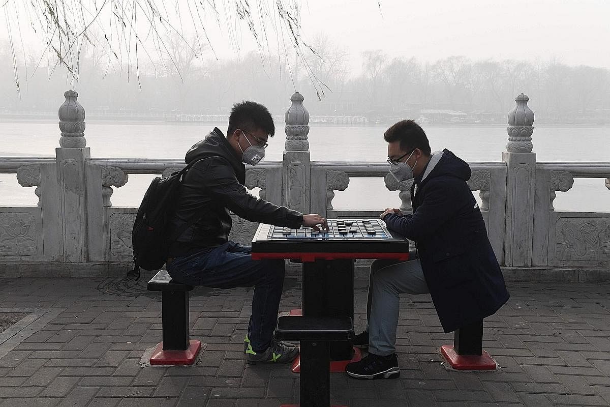 Smog cannot checkmate the passion of two chess enthusiasts who continue to hone their skills under less than ideal conditions. Conditions are also no better in Hubei province where buildings struggle to stand out amid the dense smog swirling in Xiang