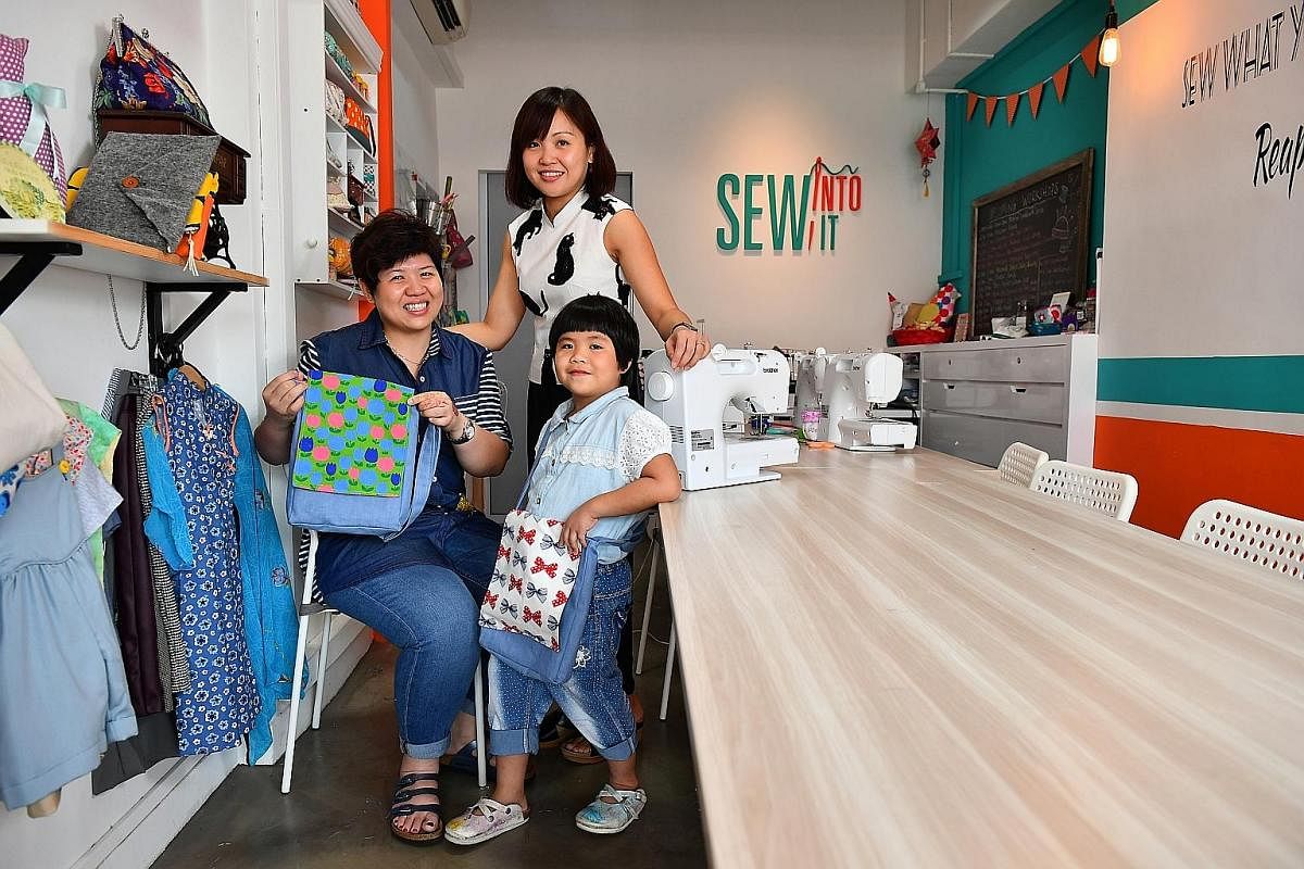 Co-founder of Sew Into It Amy Toh (standing) with her students Ng Hui Ling (sitting) and Ms Ng's daughter, Janelle, who learnt to make messenger bags. Members of Pasir Ris Sewing Ladies (from far left) Ms Romnah Omar, Ms Suhaila Jamat, Ms Hamidah Mik