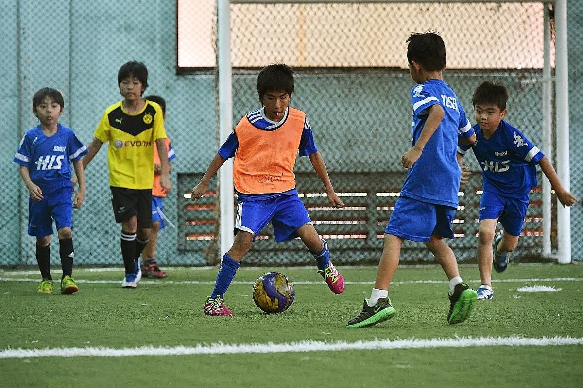 Children playing on the pitch at The Cage (above). The Home United Youth Football Academy (left) has 12 pitches.