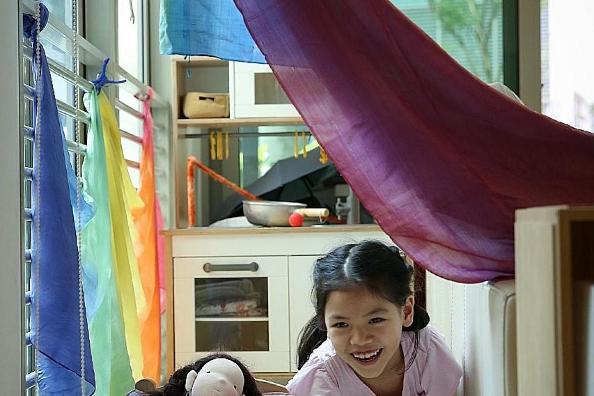 Eight-year-old Ng Xi Lin in the makeshift play area behind the living room sofa in her home.