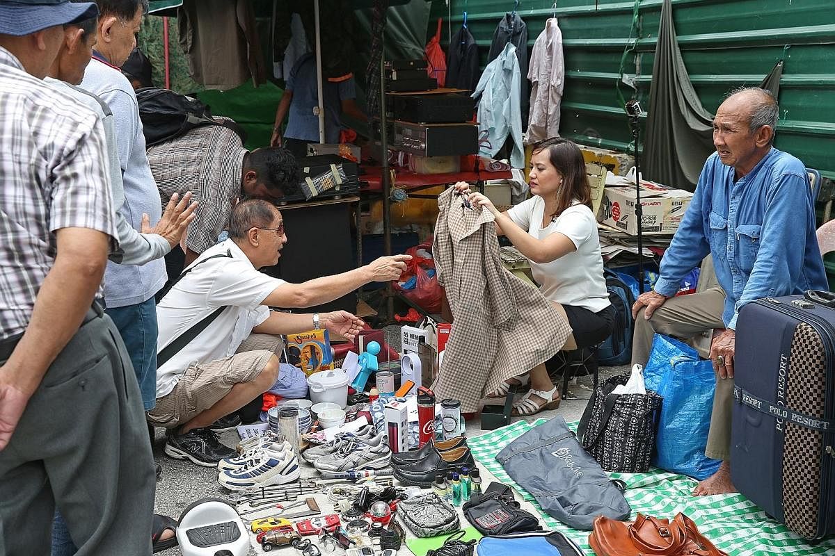 Straits Times journalist Melody Zaccheus selling items, donated by her colleagues, at the Sungei Road flea market on Feb 25. Profits go to the ST School Pocket Money Fund.