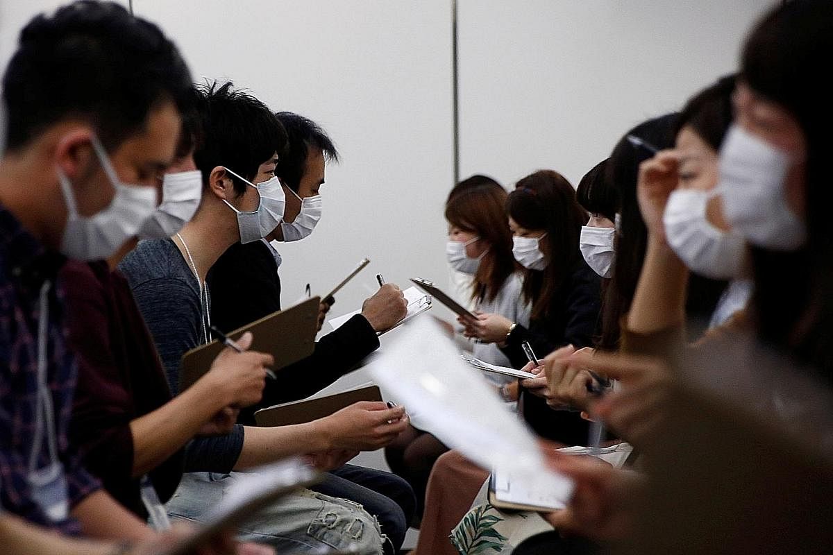 Masked matchmaking events - like this one (far left) in Tokyo last October - aim to encourage participants to get to know each other without being judged on looks. (Left) Spring in Tokyo comes with blooming cherry blossoms and hay fever, which affect