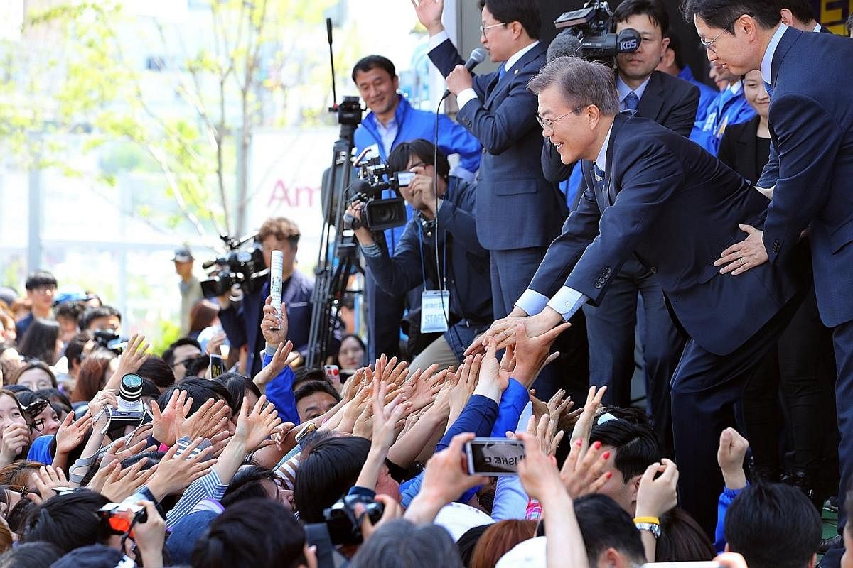Above: Ms Sim Sang Jeung, the Justice Party's presidential candidate, greeting a union leader during a campaign stop at Hyundai Heavy Industries in the south-eastern city of Ulsan late last month. Left: A supporter of Ms Sim all set to take part in a