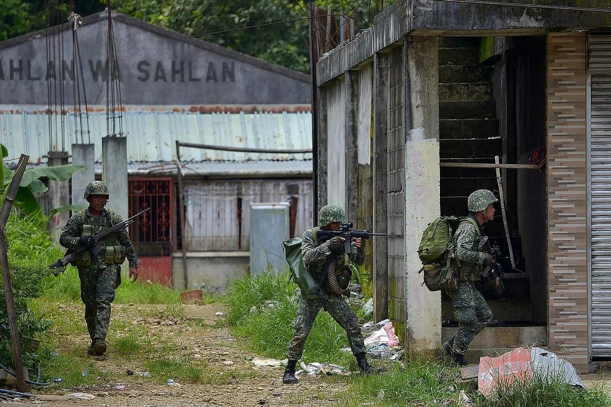 Philippine marines about to launch an assault on an Islamist militants' hideout in Marawi on the southern island of Mindanao last Saturday. Almost 180 people have died since the siege began. Displaced villagers taking shelter at a gymnasium turned in
