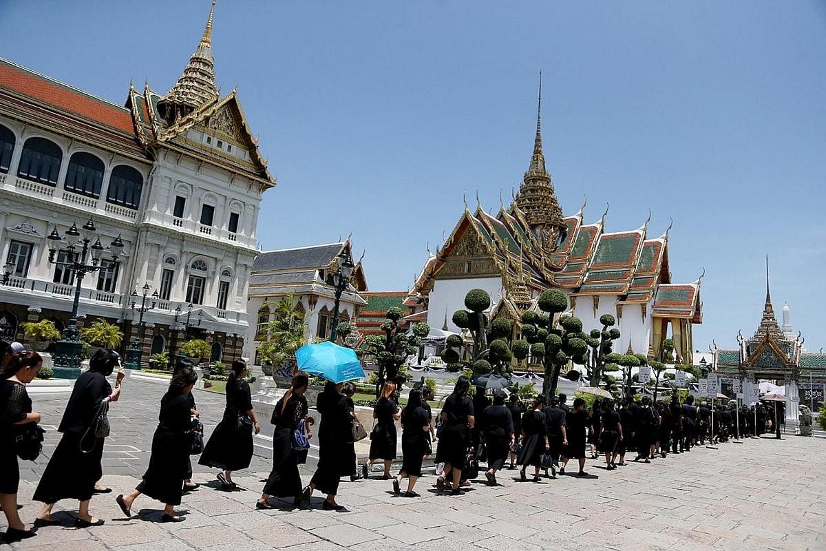 Thais holding portraits of King Bhumibol Adulyadej as they line up to pay their last respects at the Grand Palace in Bangkok last October. There will be 200 sculptures, including those of 40 gods, 20 garuda and over a hundred animals, that will be po