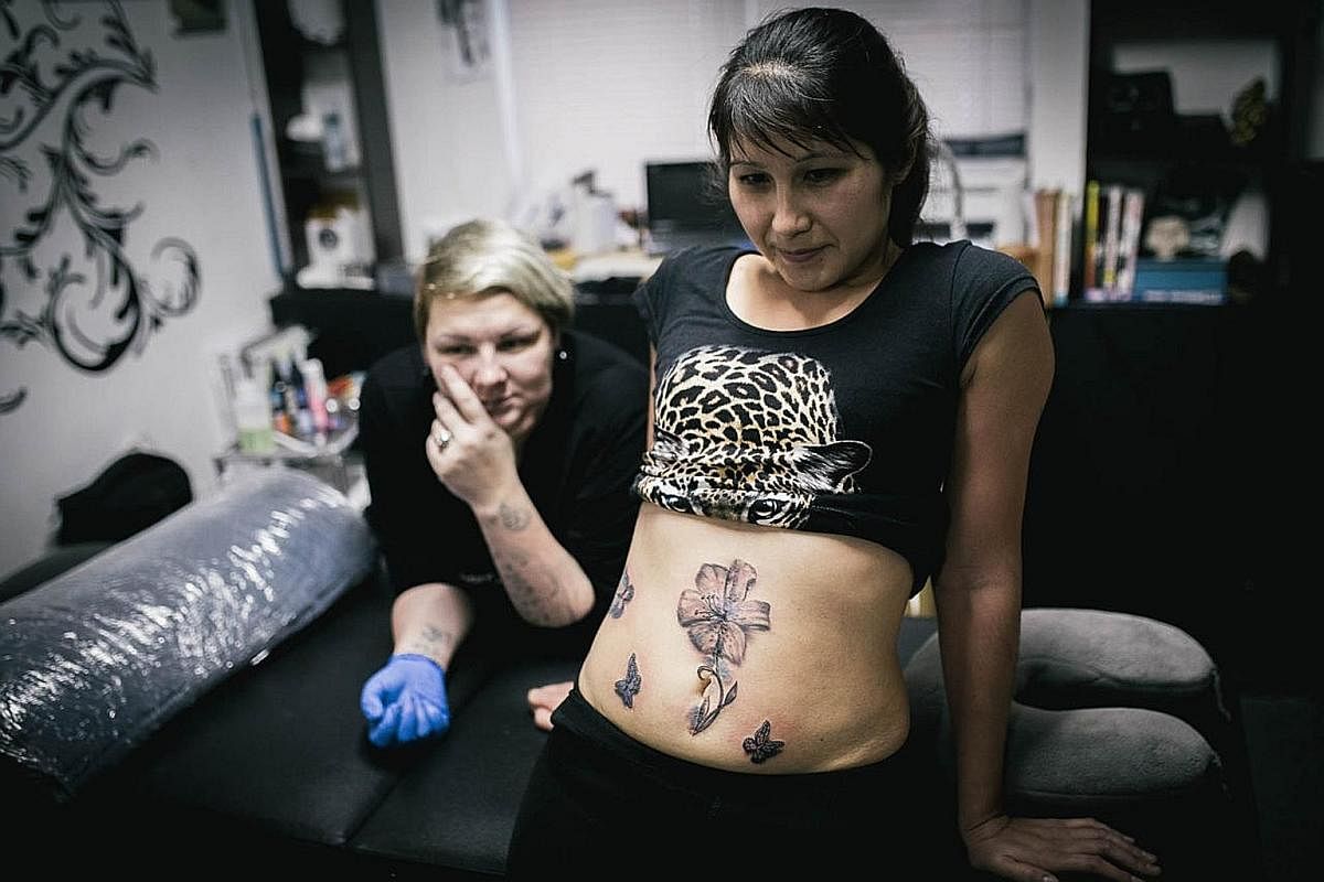 In Russia, 36,000 women are victims of domestic violence every year, with 12,000 killed as a result. A young tattoo artist, Ms Evguenia Zakhar (left), is working on the scars of abused women and turning them into art - for free.