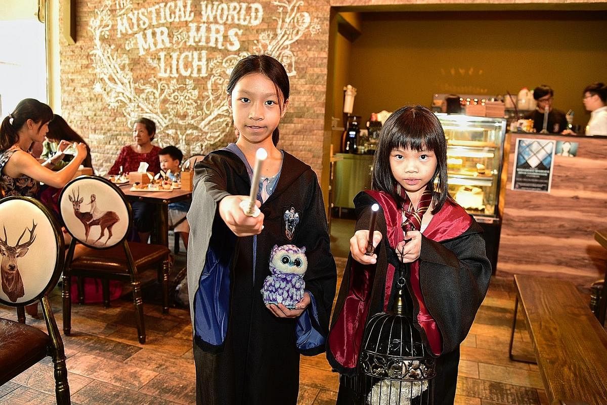 Sisters Faith and Noelle Ow Yong, who are 10 and eight, at a Harry Potter tea party at wizard- themed cafe Platform 1094 to mark the 20th anniversary of the publication of Harry Potter And The Philosopher's Stone.