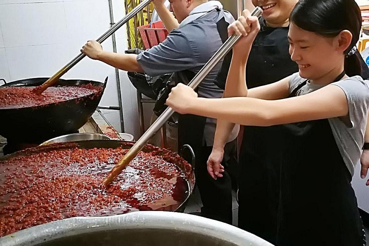 Phoebe working with chef Wayne Liew (below left) of KEK Pandan Gardens and Good Chance Popiah's owner Boon Kai Chun. Her bottled chilli paste (above) costs $15 each.
