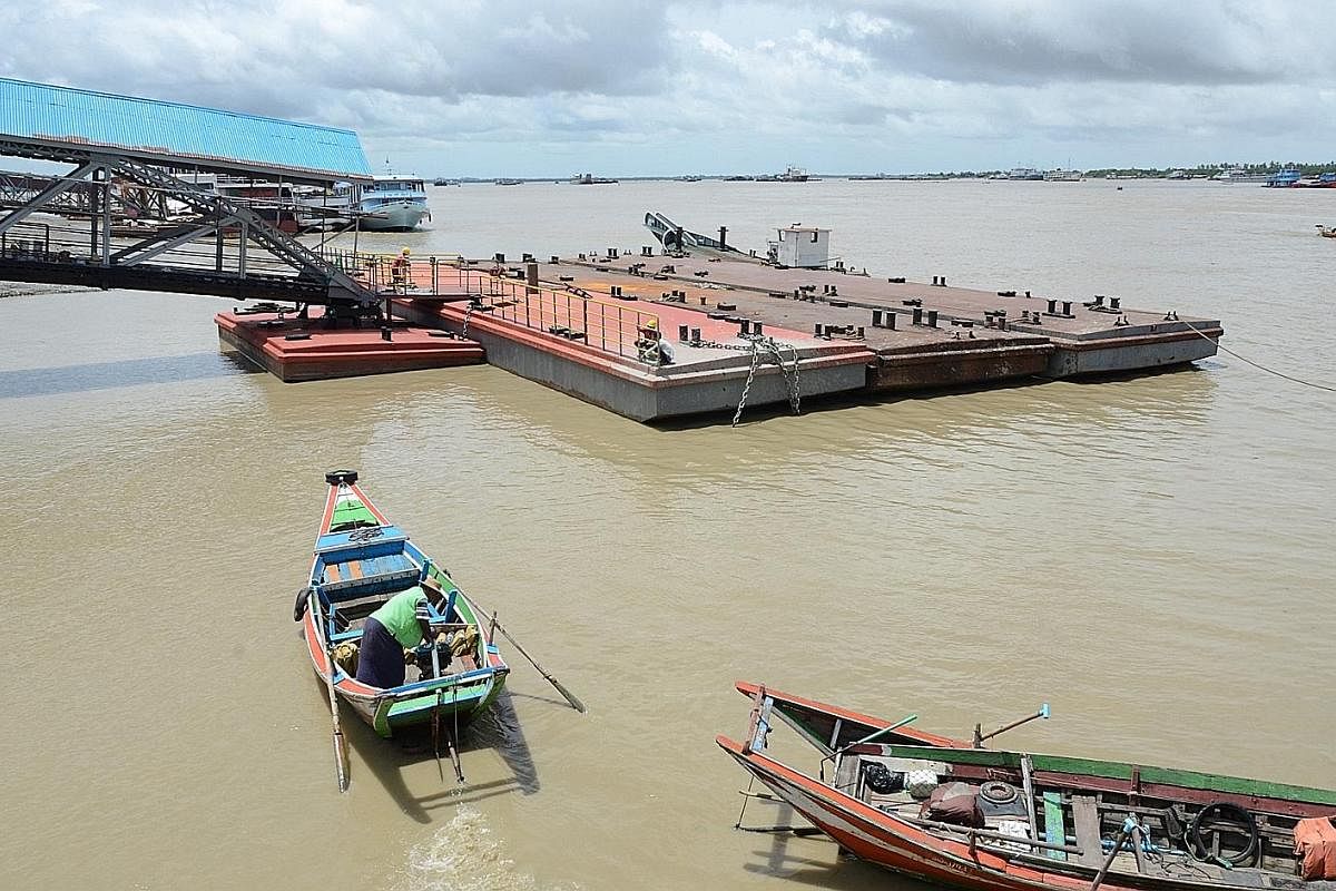 Workers preparing a platform at Botataung Pier for a future boat service that will hopefully take commuters off the roads and ease traffic jams.