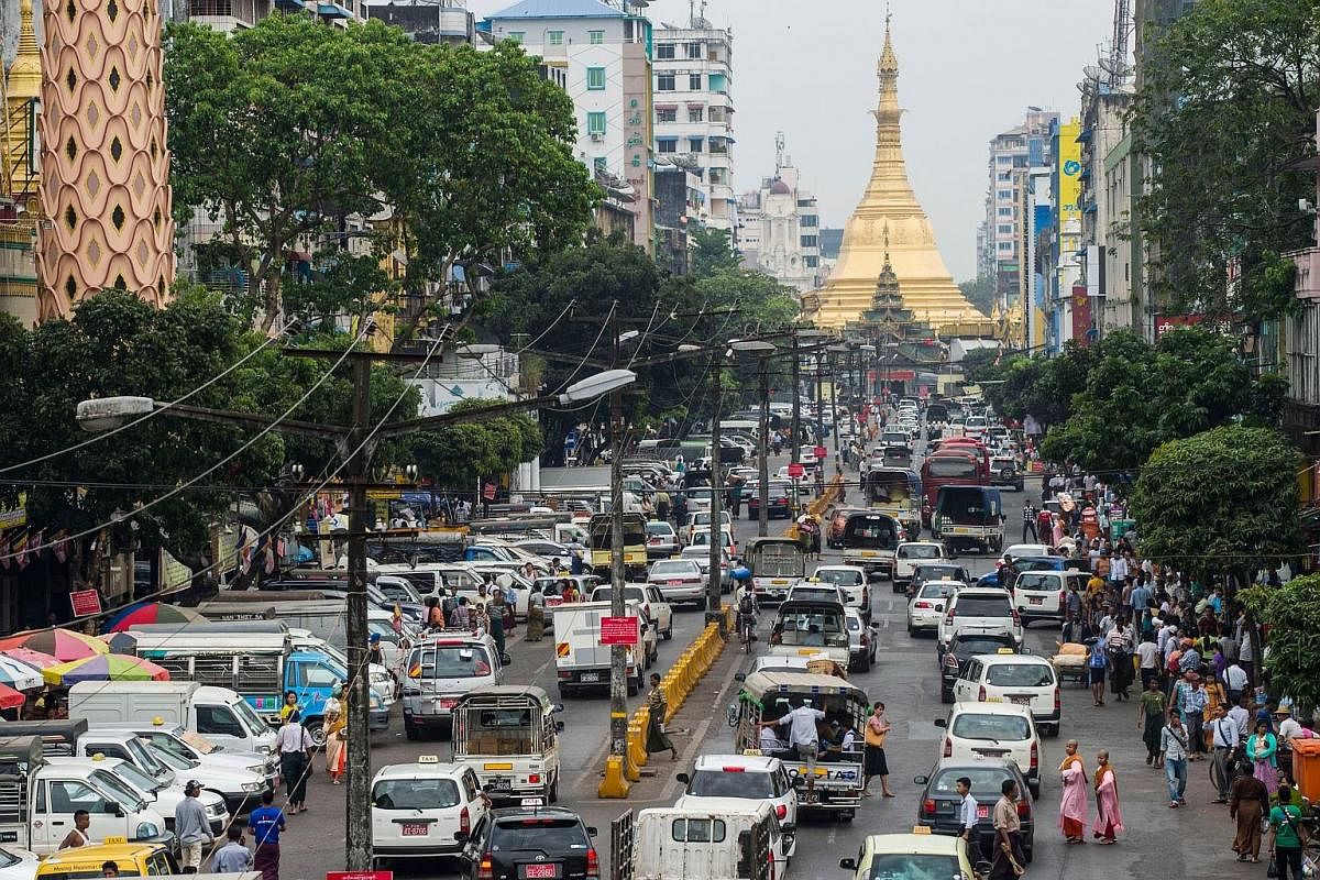 Heavy traffic in Mahabandoola Road, with the Sule Pagoda in the background, in central Yangon in January. Myanmar's largest city is growing rapidly, and with more cars and few parking spaces, stationary vehicles take up room on the roads, squeezing out th
