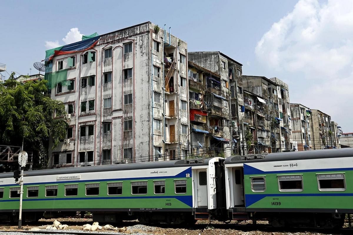 An outbound train stopping near an apartment building in Yangon. The city's ageing trains serve only 1.5 per cent of travellers.