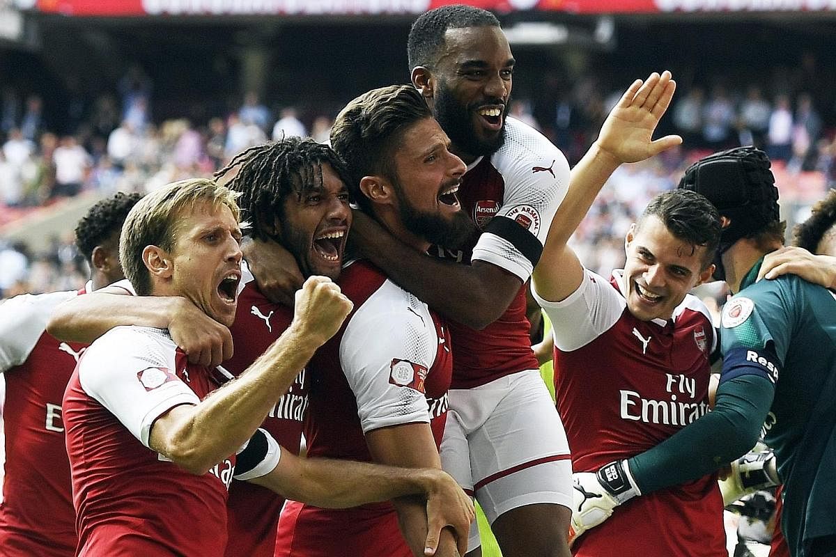 Olivier Giroud (third from left) celebrating with his team-mates after scoring the winning penalty for Arsenal in a shoot-out following the 1-1 draw with Chelsea in the Community Shield on Sunday.