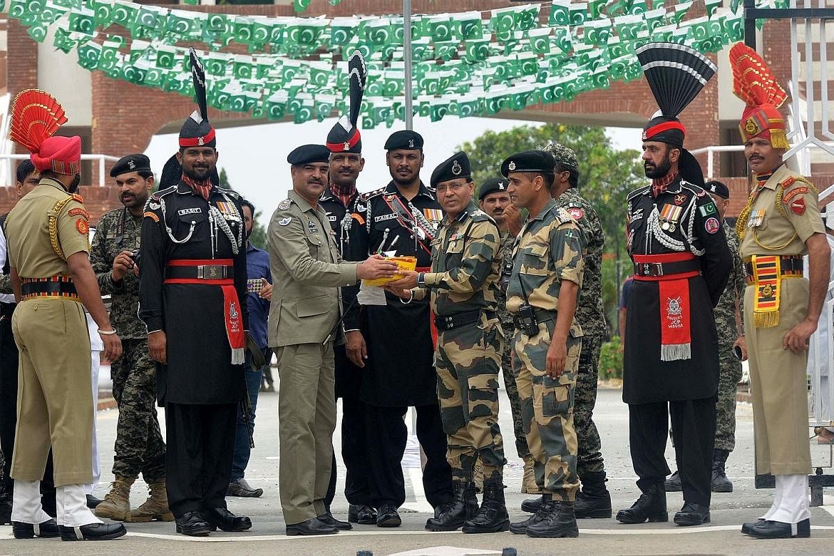 A Pakistani commander (second from left) presenting sweets to an Indian Border Security Force commandant at a ceremony to mark Pakistan's Independence Day at the India-Pakistan Wagah border post yesterday. Pakistan marks independence on Aug 14 each y
