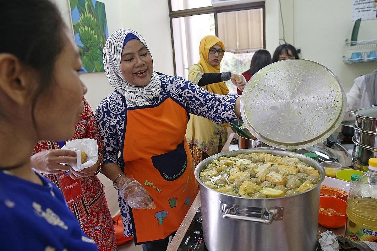 Ms Atik Setyamurti, 42, getting ready to taste a pot of "bakso" (Indonesian meatball soup) which she and several other Indonesian friends prepared for the Hari Raya celebrations in July. The Indonesians spent the whole morning cooking food at the clubhous