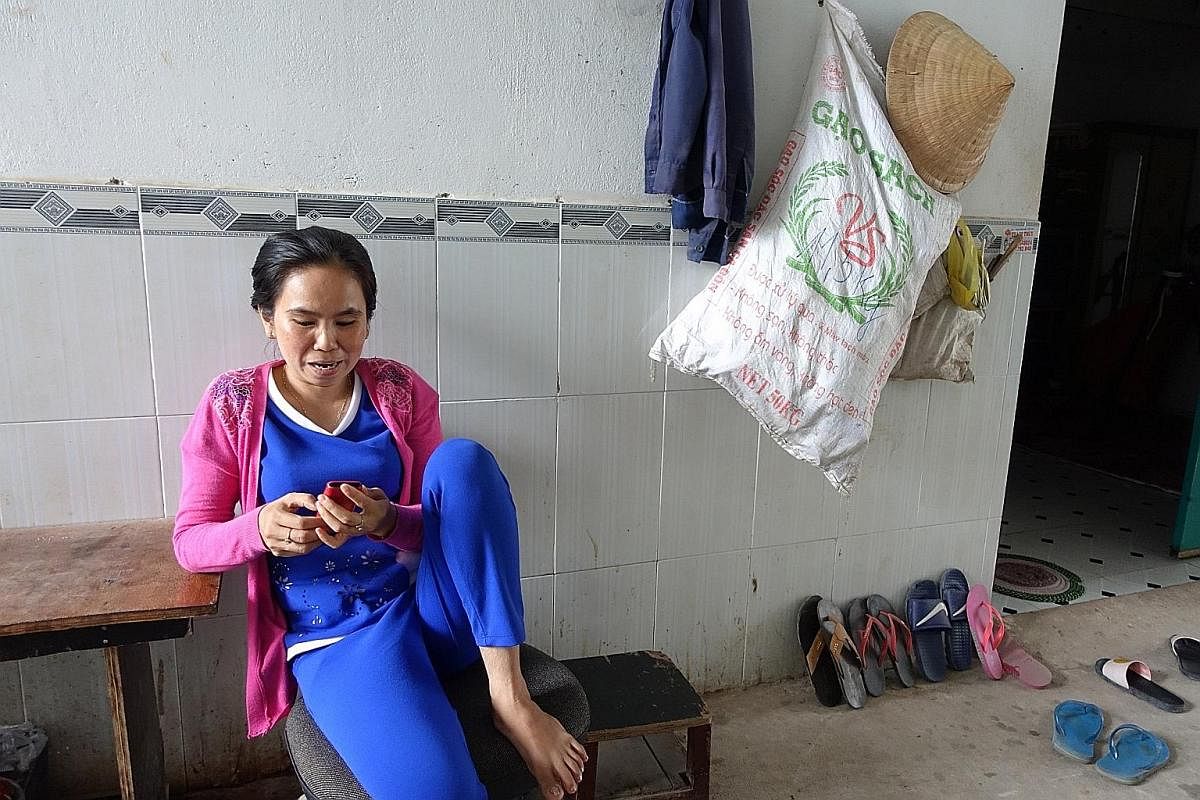 VIETNAM A migrant family relaxing outside their room in the village. The rooms in urban lodgings for migrants tend to be cramped and squalid, giving communal spaces an added importance. Migrant worker Vo Thi Kim Phuong getting some air outside her wi