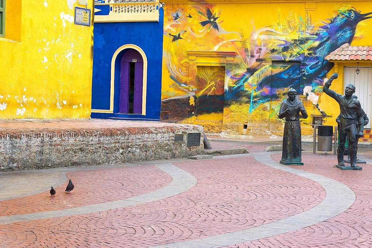 Statues and a mural in Santisima Trinidad Plaza in Cartagena, Colombia.
