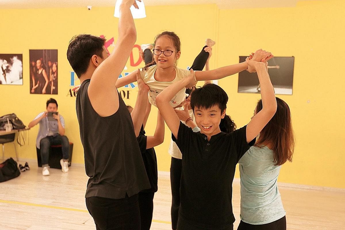 From far left: Mikey Robinson, 12, and Bastien Buwalda, 12, clown around as Verlene Chew, 12, adjusts 12-year-old Natanya Tan's hat, and Laura Maurer-Stroh, 10, waits in a room with other performers for a full-dress rehearsal to begin last Saturday. 