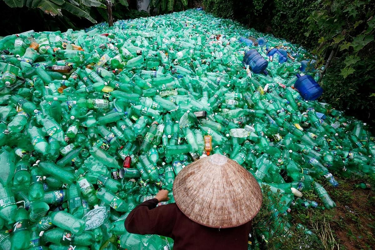 A woman sorts recyclable plastic bottles outside Hanoi. Between 60 per cent and 70 per cent of marine plastic waste comes from China, Vietnam, the Philippines, Indonesia and Sri Lanka. Dense plastic waste chokes the shoreline of a village in the Solo