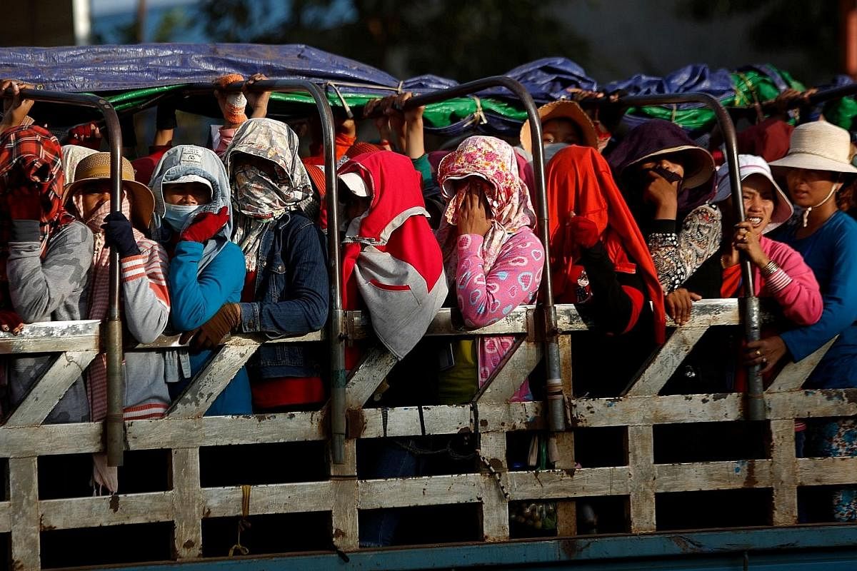 Garment workers standing at the back of a truck as they return home after work, in Kampong Speu province, Cambodia, in October.