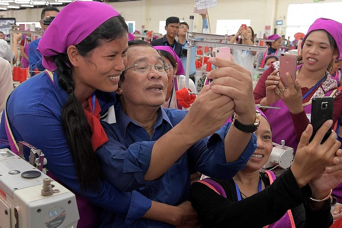 Cambodian Prime Minister Hun Sen taking a selfie with workers at a factory on the outskirts of Phnom Penh in August. There has been a concerted effort by the ruling party to woo workers in the industry. Clothes on sale at a street stall in Phnom Penh