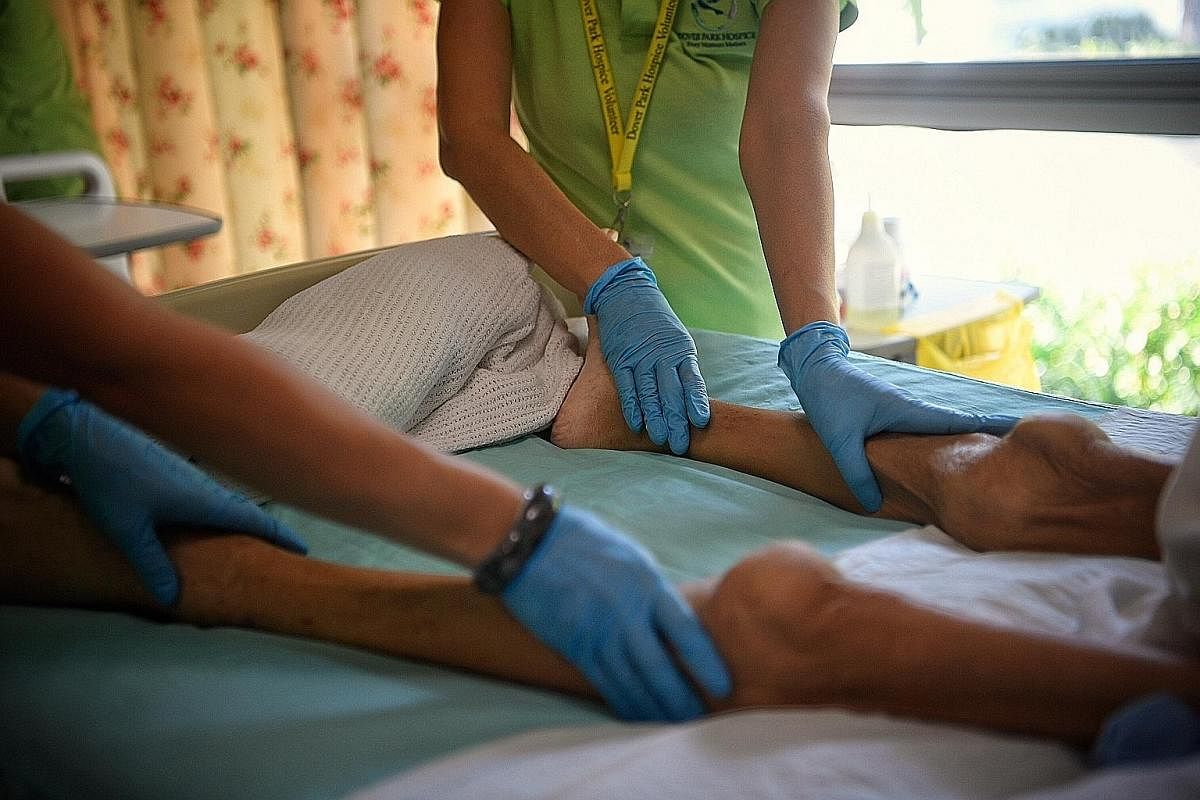Full-time volunteer Mabel Pek (centre), 61, with 44-year-old teacher Chow Wai Mun, massages a resident’s legs during a weekly massage-therapy session. Ms Pek heads a team of around 10 volunteers, and has trained over 100 in the art of Swedish massage. It 