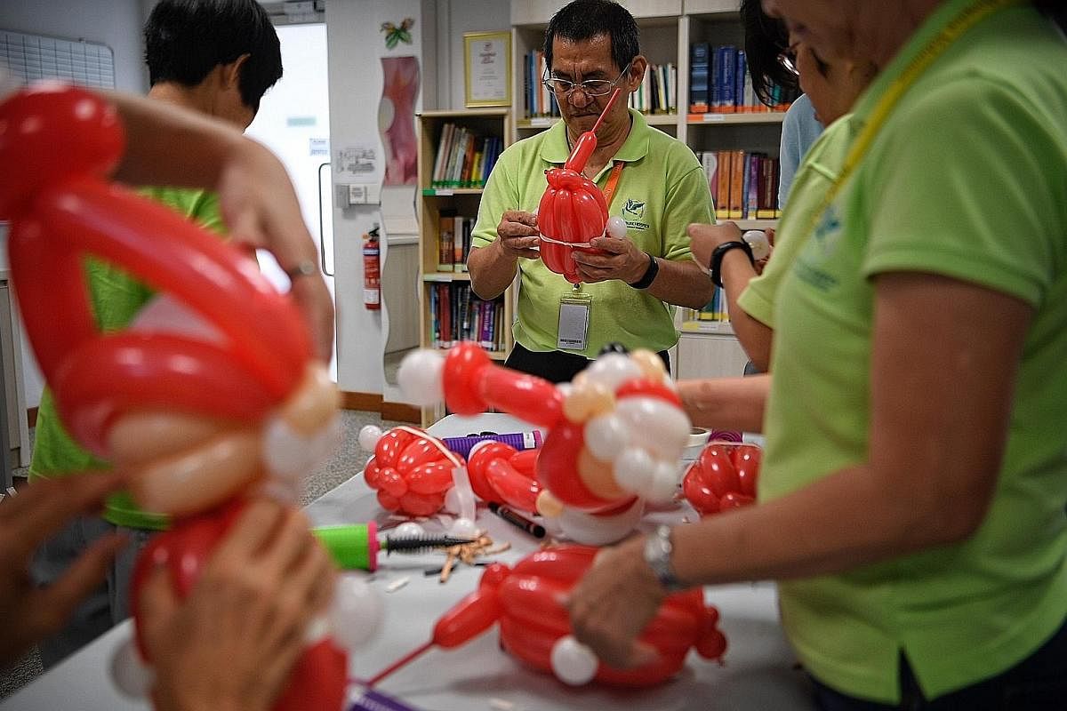 Mr Johnny Oh, a 59-year-old electrical maintenance officer and volunteer of 11 years, learns to sculpt balloons during a workshop at Dover Park Hospice. Under its Continuous Volunteer Education programme, Dover Park organises classes regularly to teach ne