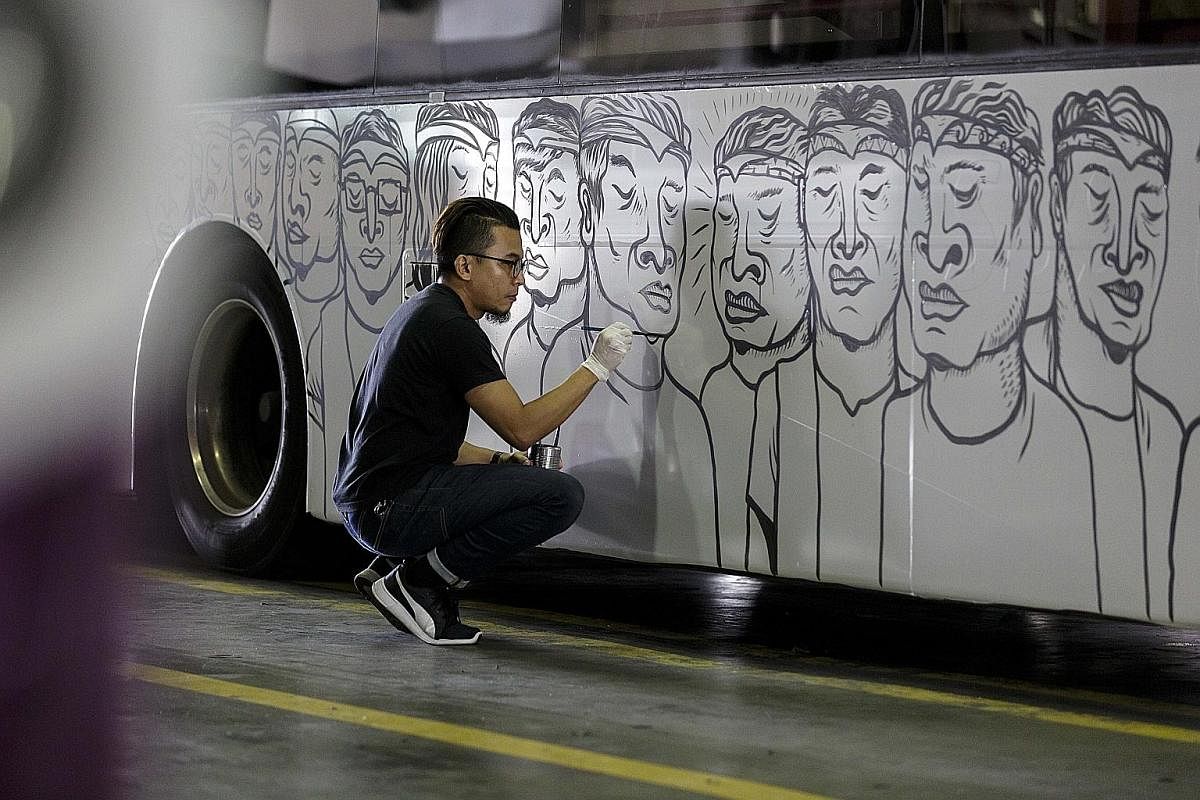 Farizwan Fajari painting an SBS bus for the ArtScience Museum's upcoming exhibition of street art, where his work will be shown.