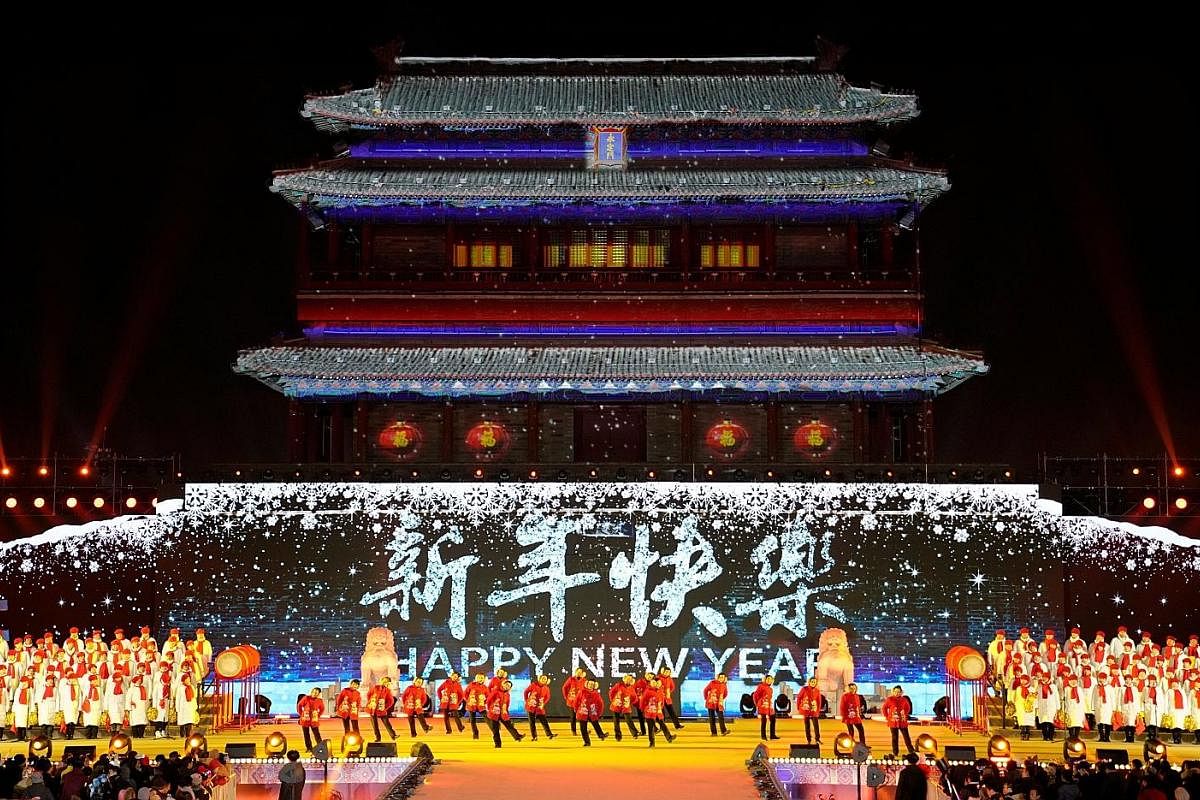 NEW YORK CITY (above): Revellers playing in a sea of confetti at Times Square. BEIJING (left):People dancing during a countdown event at Yongdingmen Gate in the Chinese capital. BOROBUDUR: People releasing lanterns at Borobudur temple in Magelang, In