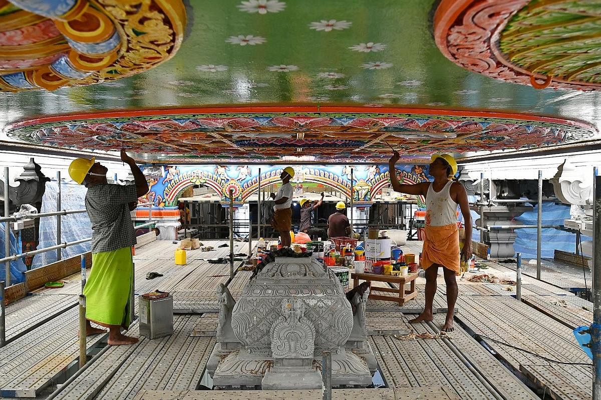 Mr Viswanathan Karunanithi (left), 47, and Mr Karuppaiyan Chidambara-nathan (right), 48, two of the 20 skilled temple artisans from India, painting motifs representing Indian astrology signs on the ceiling above the Garudar sanctum. The men are worki