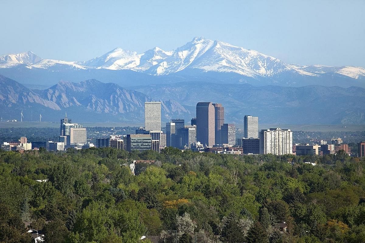 Downtown Denver's skyscrapers are set against the snow-covered Longs Peak, part of the Rocky Mountains.