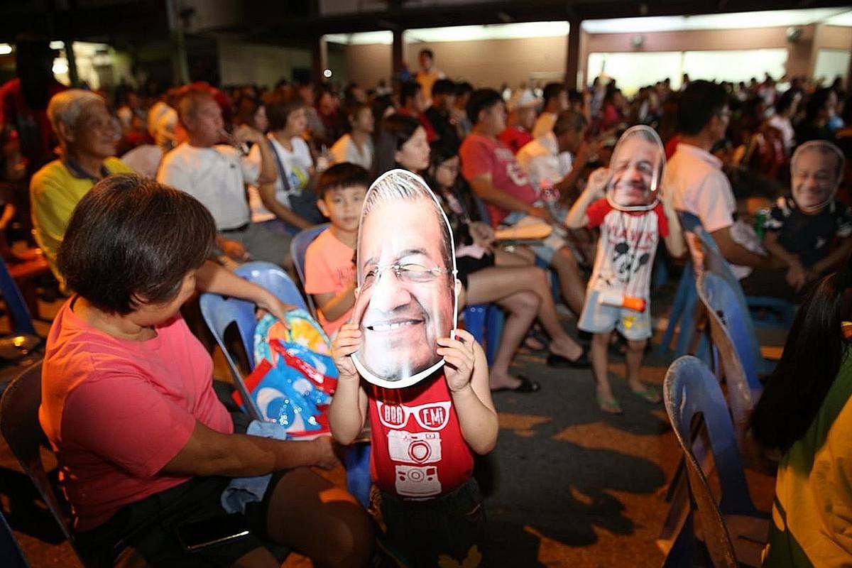 Supporters cheering for former prime minister Mahathir Mohamad, who is the chairman of opposition pact Pakatan Harapan, at a rally in Mutiara, Melaka, last Friday. A life-size hologram of Datuk Seri Najib being beamed from trucks equipped with hologr