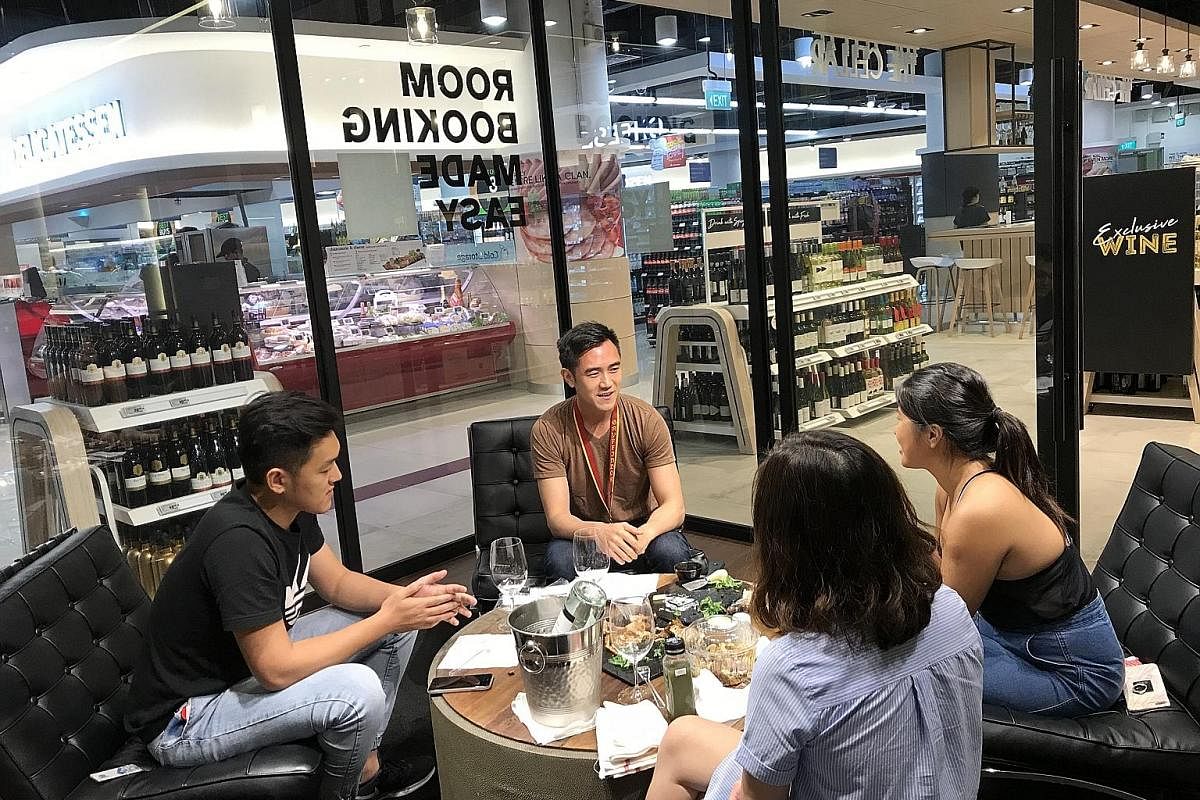 Digital marketeer Tan Chun Hao (left, centre) having lunch with his colleagues in The Den, one of two meeting rooms at Cold Storage at Fusionopolis. The outlet also has a dining area (left, below) that seats 12 and is equipped with power sockets, USB
