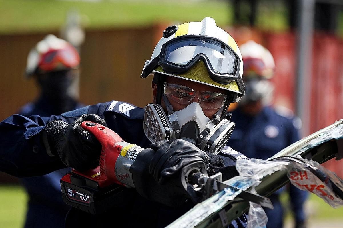 Sergeant Muhammad Shafi'i Rahmat, 30, wielding a portable cutter. Dart trainees learn to use a variety of tools, like hand-held cutters and hydraulic spreaders, needed to extract accident victims quickly from vehicles, under the watchful eye of their