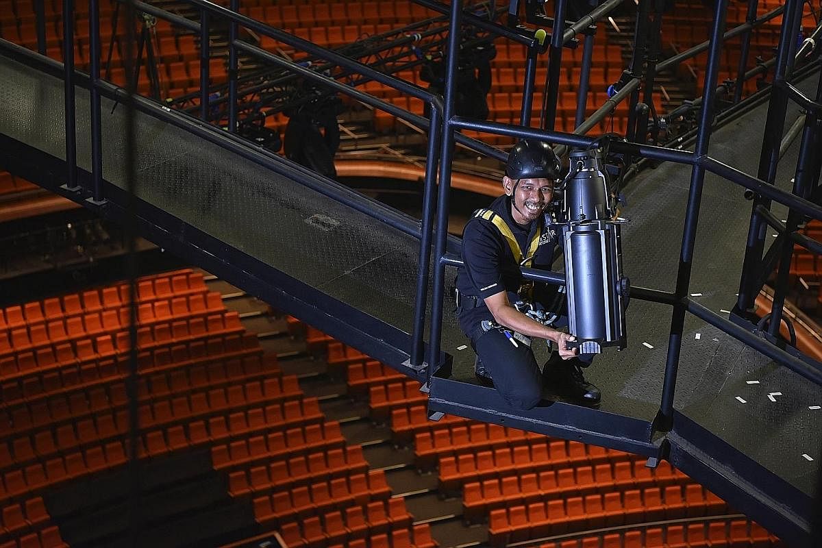 Mr Mohamad Azwan Mazlan adjusting light fixtures on the catwalk at the Star Performing Arts Centre