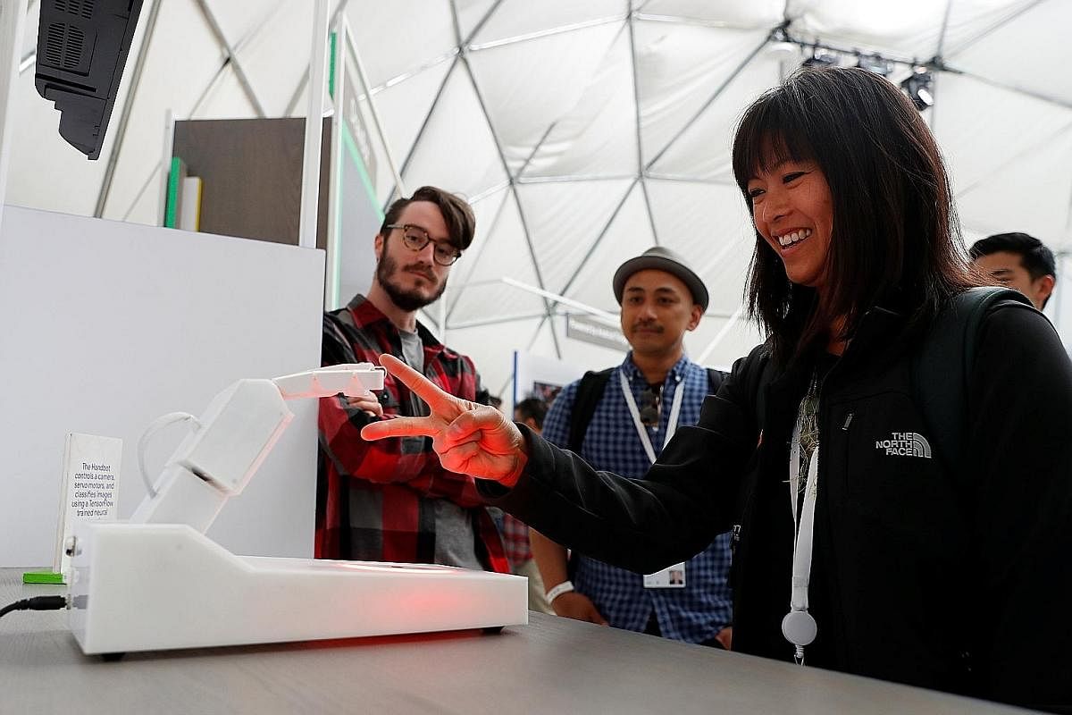 An attendee at the annual Google I/O in Mountain View, California, last week playing rock, paper, scissors with a Handbot robot.