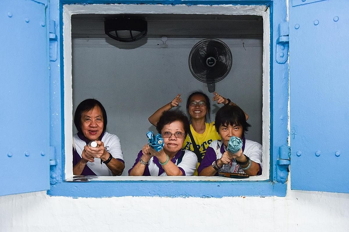 (From left) Madam Linda Lim Sor Bee, 70, Madam Tan Quee Choo, 66, Ms Klara Ong Jing Hui, 21, and Madam Chow Li Chin, 64, posing for a fun shot while waiting out the rain at Fort Siloso. By the second day, there were no signs of shyness between the se