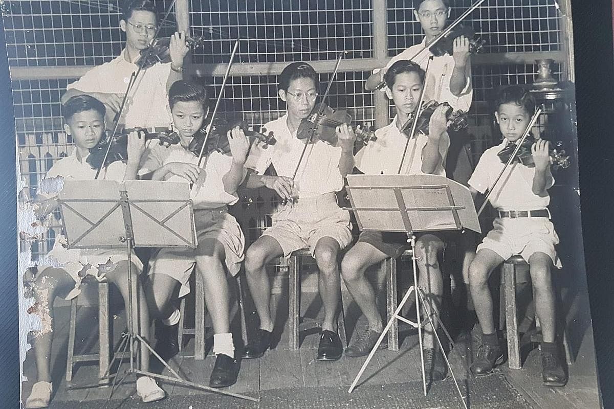 Mr Koh Seow Chuan (right) in 1951, at 12 years old, playing the violin with his brothers. A stamp collector, Mr Koh had part of his collection (above) sent to different space stations. Mr Koh in 1956 with his swimming trophies (left), before departin